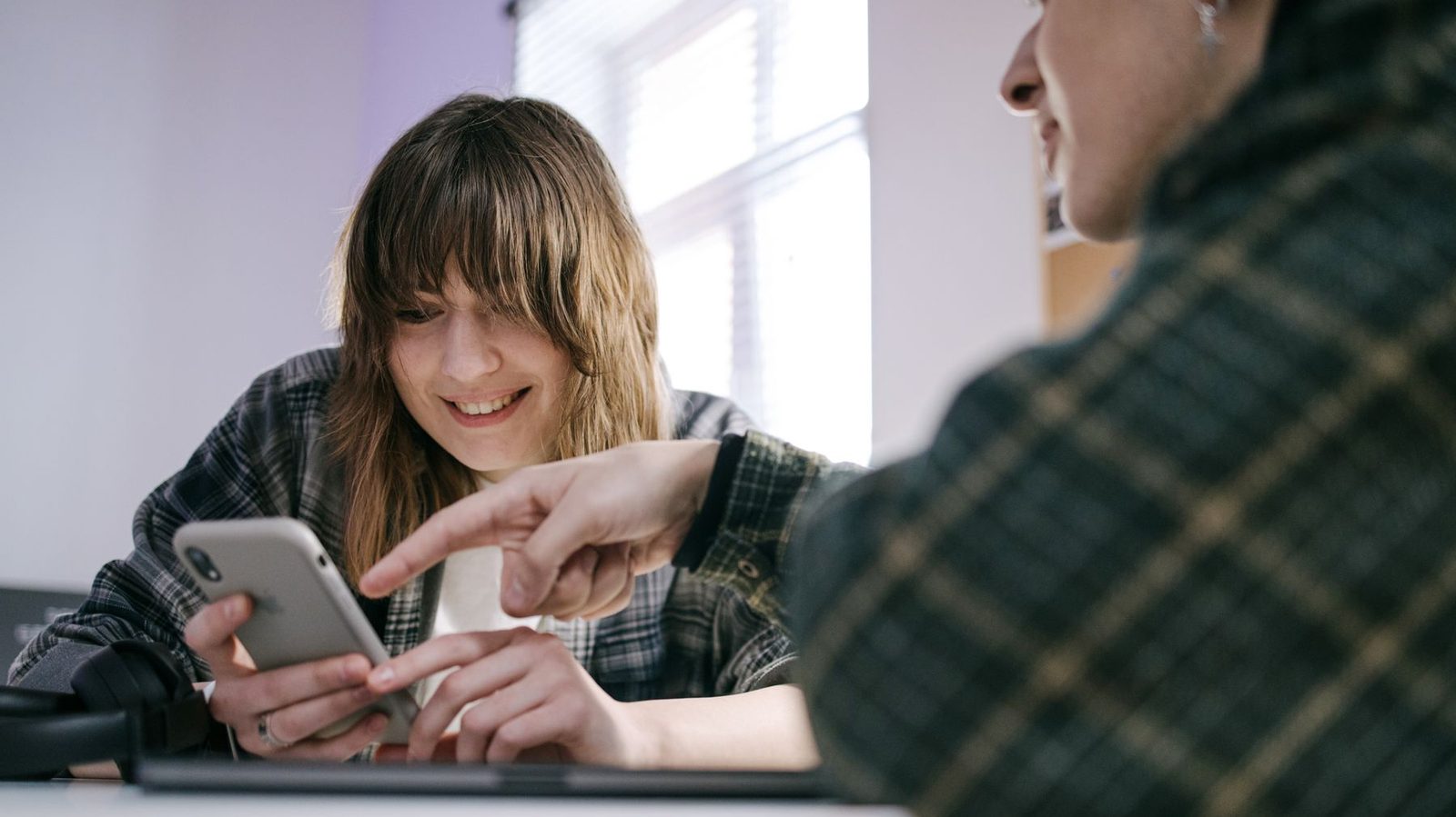 One person showing another something on their phone, which is where a recommendation actually starts