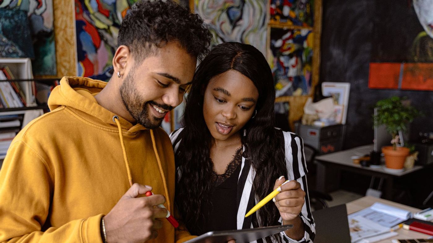 Two people checking that the numbers on a tablet are the ones they expected